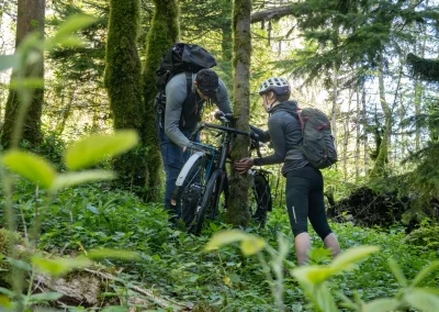 Un homme et une femme attachent leur vélo à un arbre pour partir grimper, Aventures sans voiture - Photo © Florian Garibal