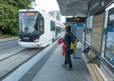 Femme qui va monter dans le tramway à Grenoble avec ses affaires d'escalades, Aventures sans voiture - Photo © Florian Garibal